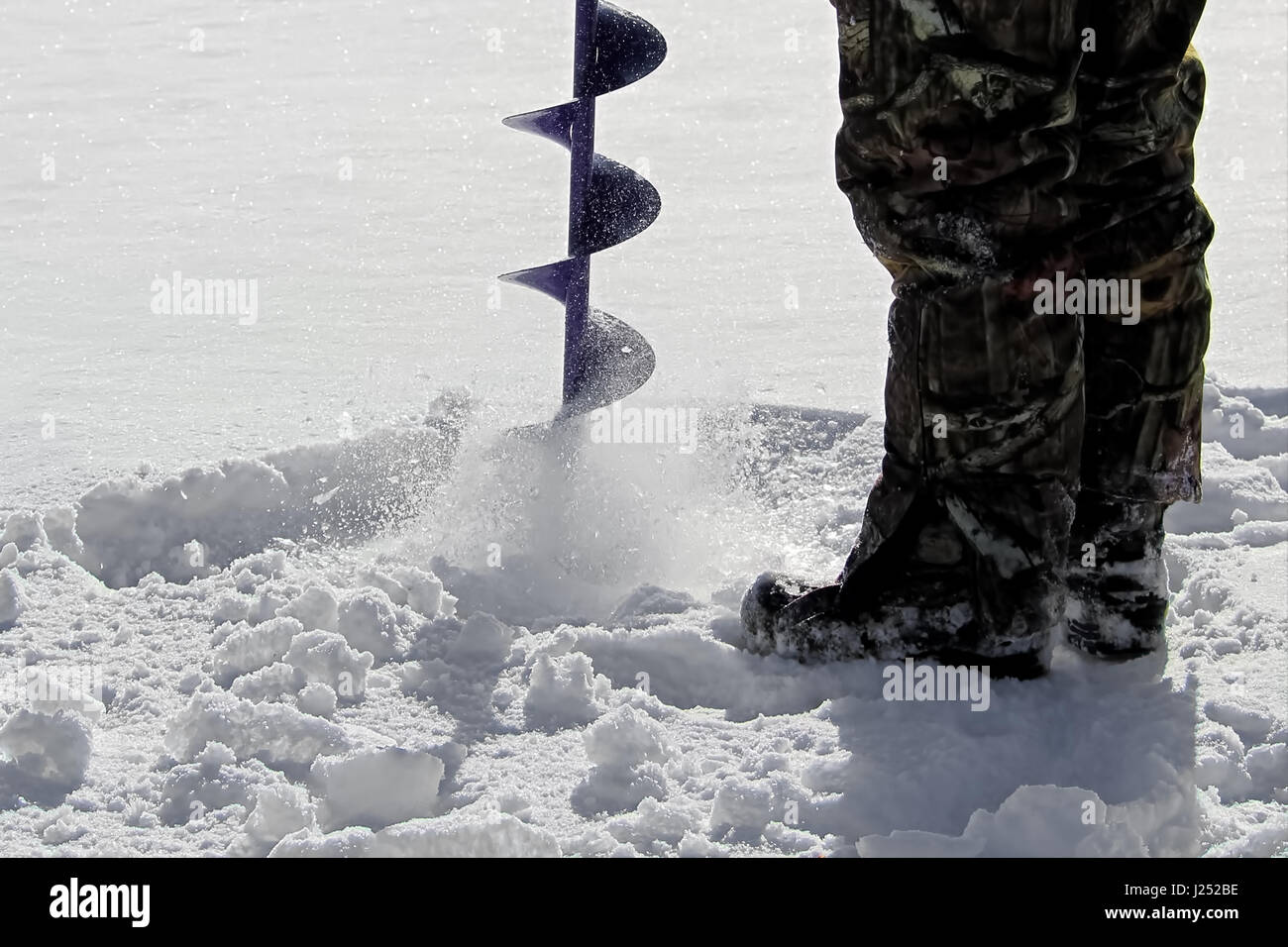 Side View of Drilling a Hole for Ice Fishing Stock Photo Alamy