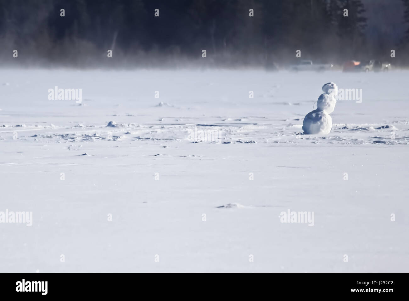 Lonely Snowman on the Middle of a Frozen Lake. Stock Photo