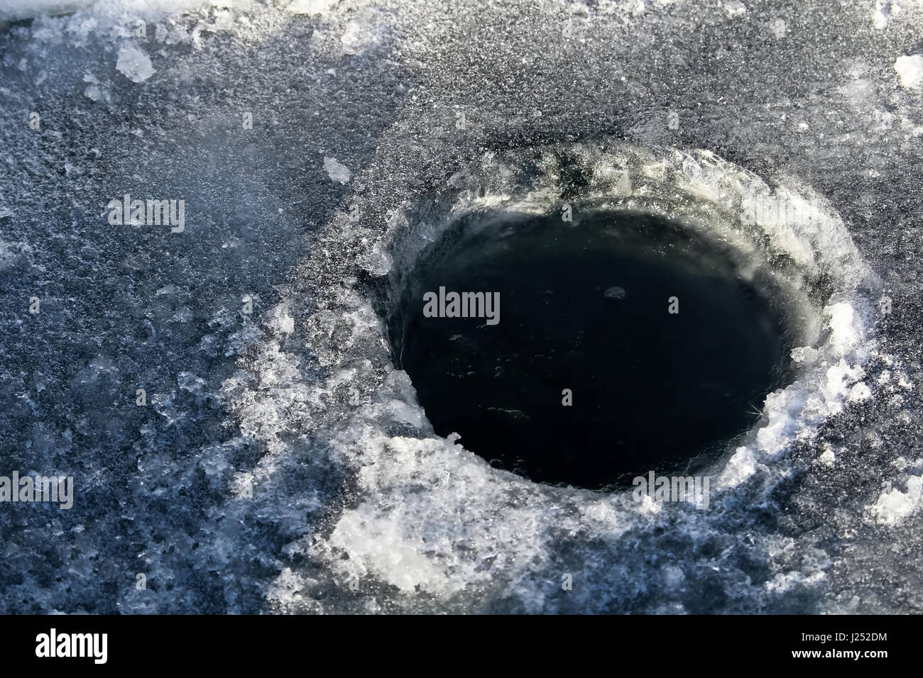 Ice Fishing Hole with Black Water. Stock Photo