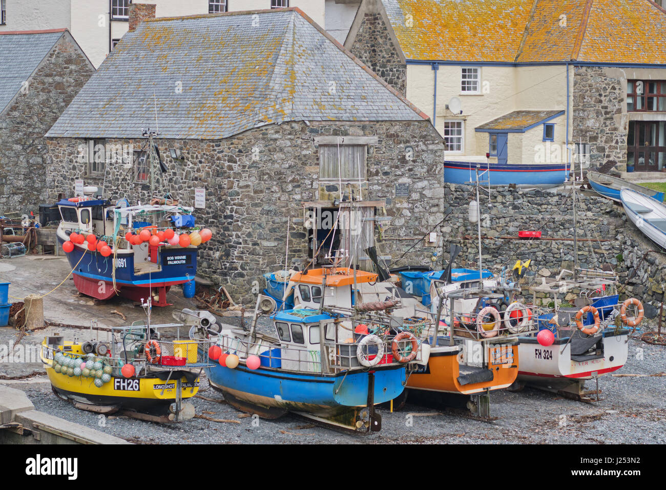 Fishing boats beached in a Cornish harbour. Their crustacean and white fish catches are a vital part of the local economy Stock Photo