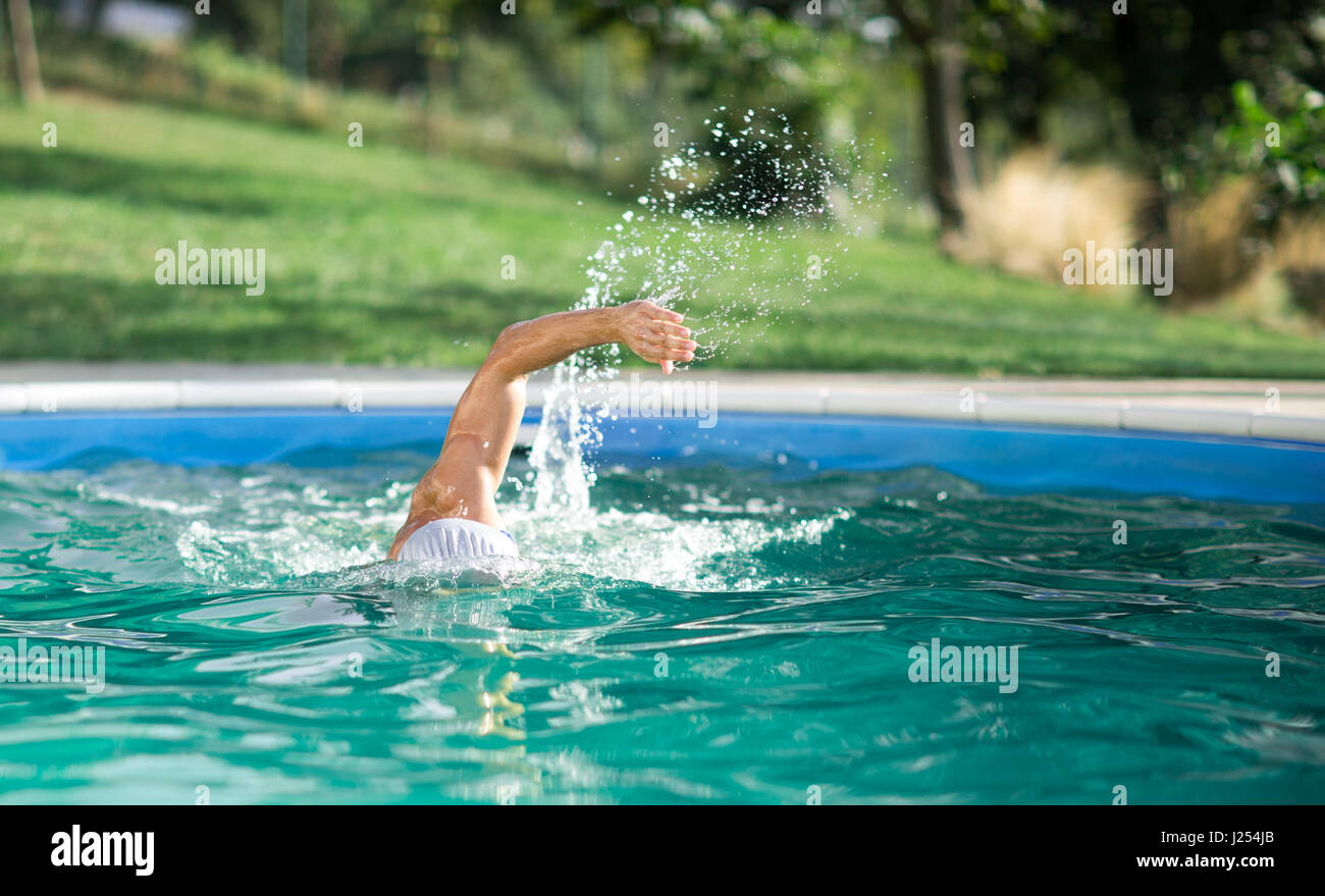 swimmer recreating on outdoor pool Stock Photo