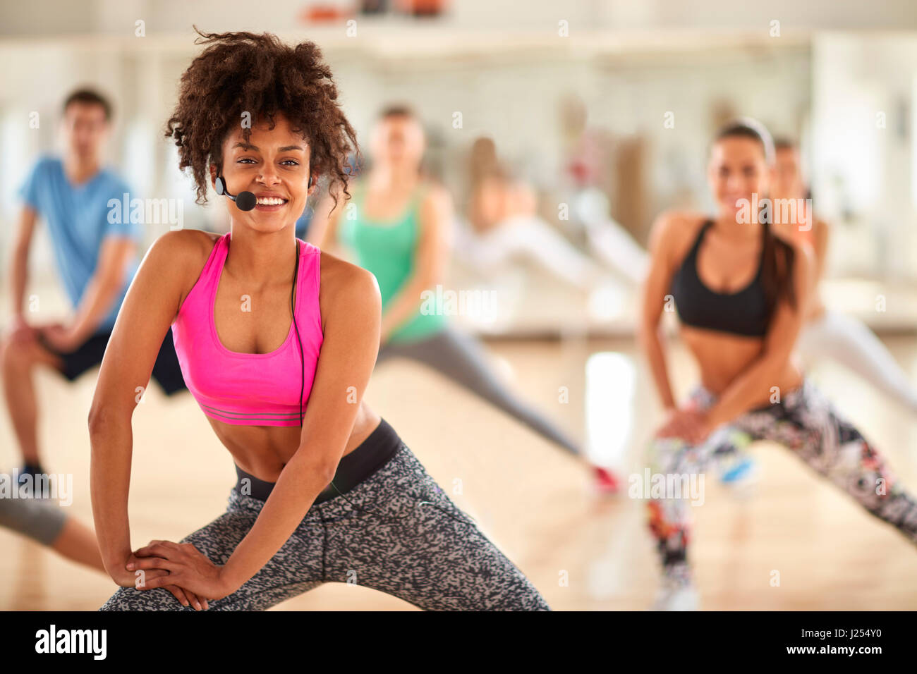 Young curly fitness female trainer in gym Stock Photo