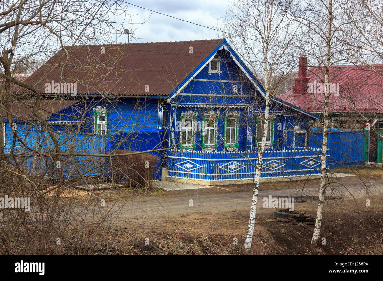 Classic Russian village house with three windows of sky blue color ...