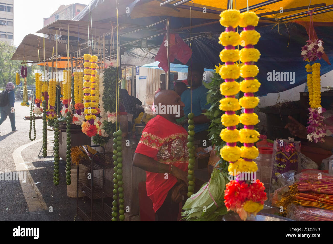 A stall sells garlands of flowers for religious purposes outside a