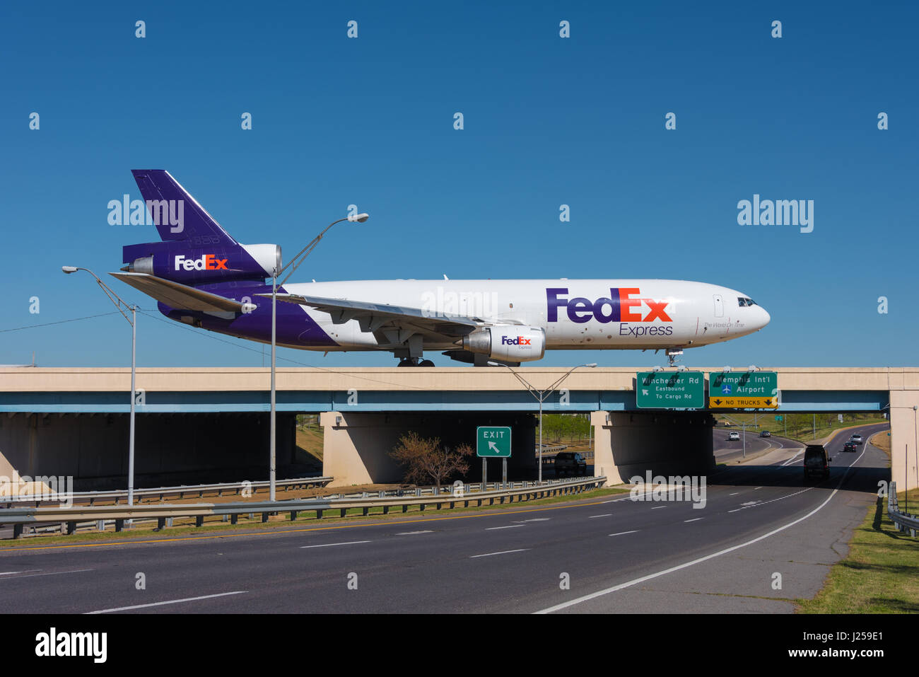 FedEx jet on taxiway bridge over terminal access road at Memphis International Airport in Memphis, Tennessee, USA. Stock Photo