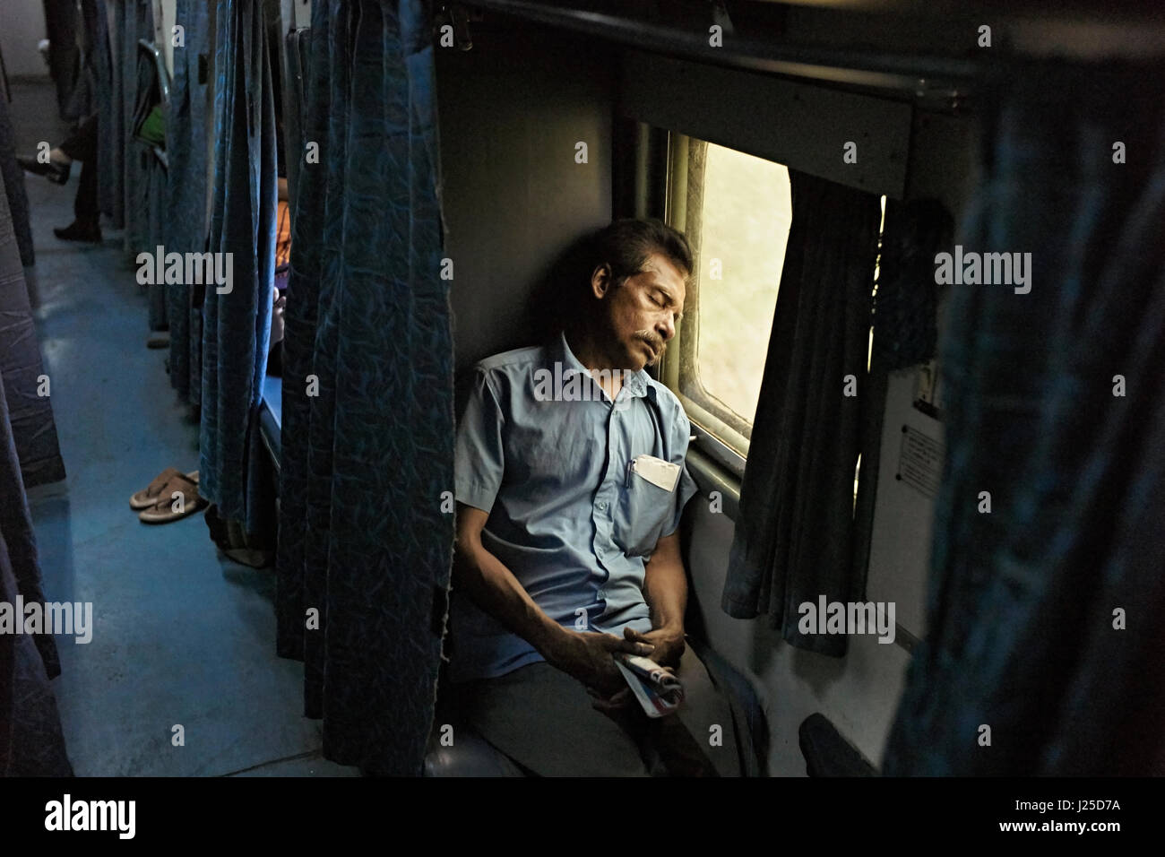 Kerala, India. Sleeping passenger aboard the Mumbai Express - train number 11042 along the Malabar Coast. Stock Photo