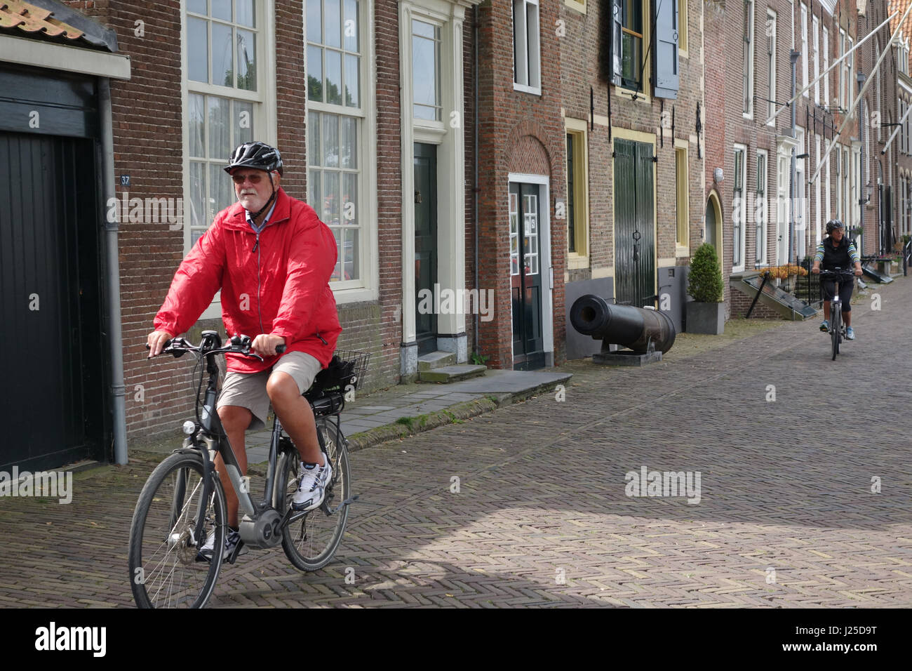 cycling through Veere town centre, Zeeland Netherlands, Europe Stock Photo
