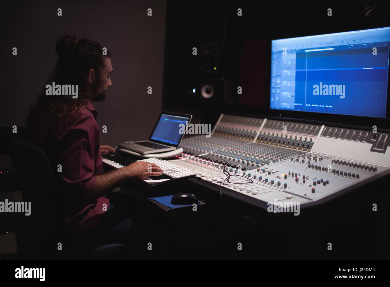 Male audio engineer using sound mixer in recording studio Stock Photo ...