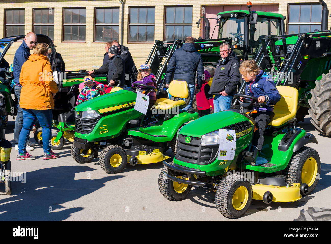 Brakne Hoby, Sweden - April 22, 2017: Documentary of small public farmers day. Families attending the John Deere tractor exhibition. Children playing  Stock Photo