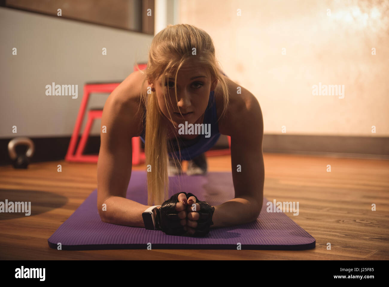 Fit woman performing fitness exercise on a gymnastic mat in the gym ...