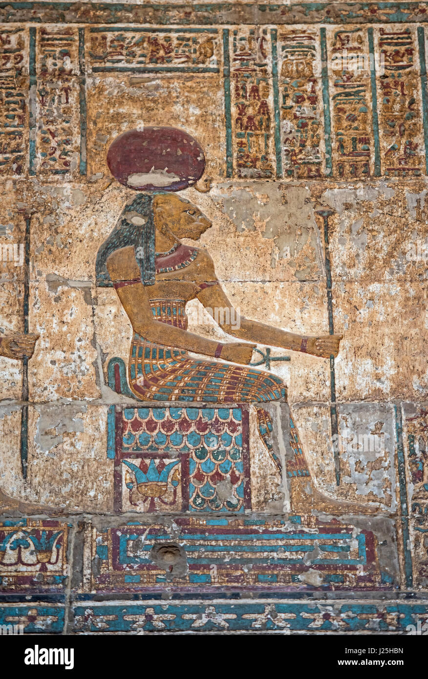 Hieroglypic colourful carving paintings on wall at the ancient egyptian temple of Khnum in Esna with god Sekhmet Stock Photo