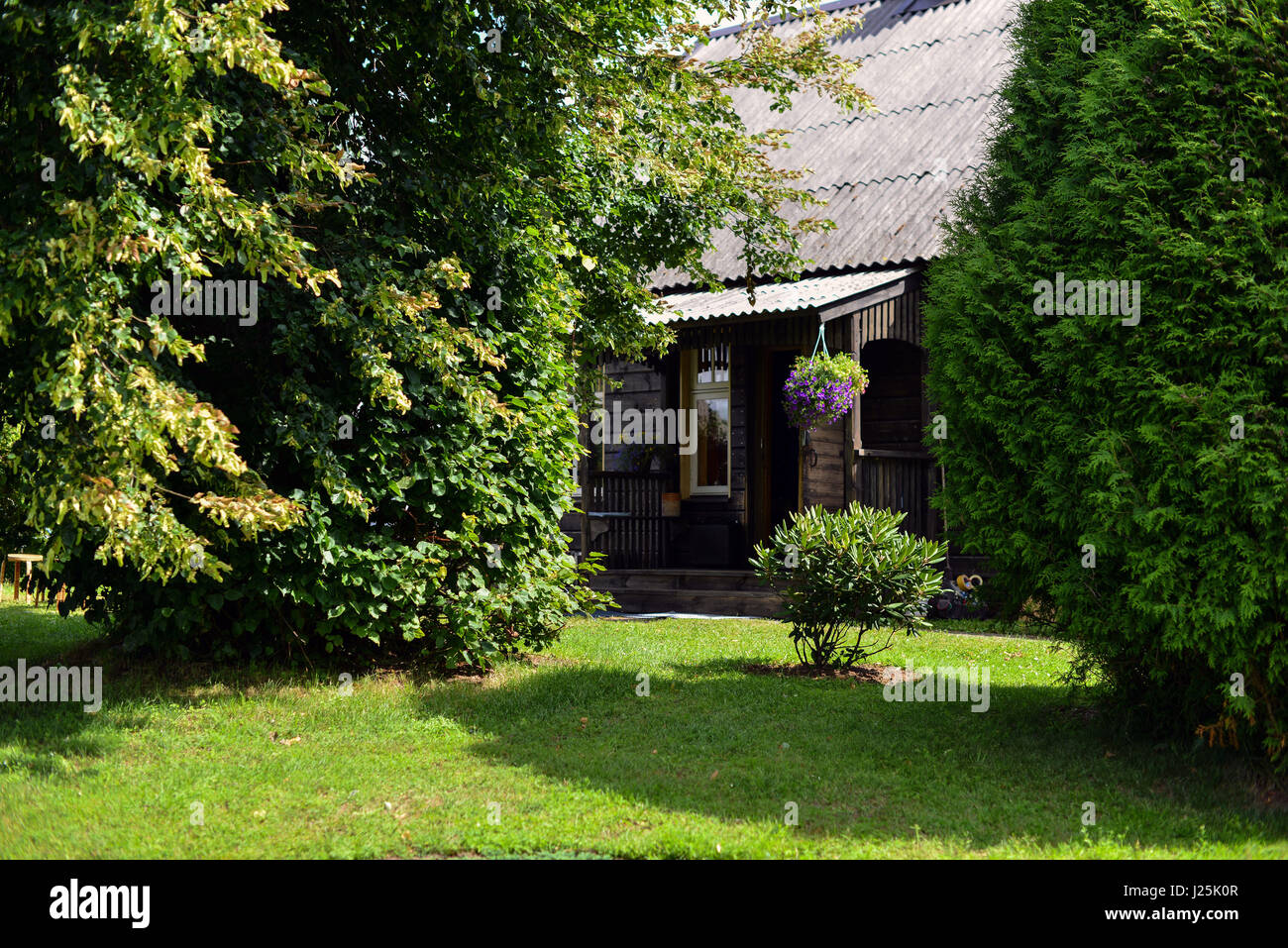 Tree surrounded farmhouse courtyard with a green lawn Stock Photo - Alamy