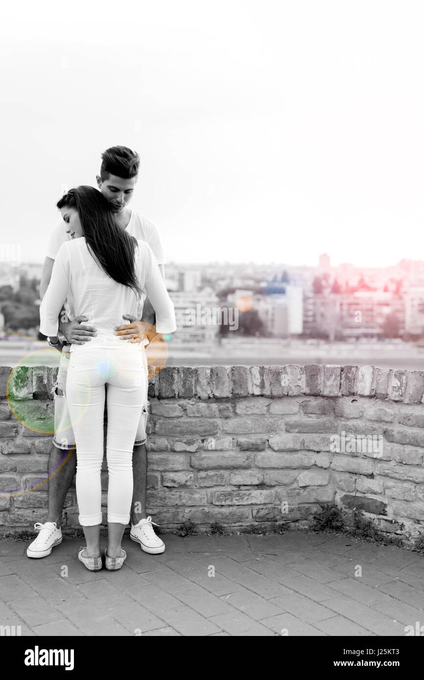 Young couple holding each other around waist and being close to each ...