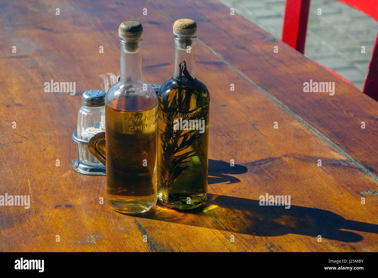 Olive oil and vinegar bottles on restaurant table in sunshine, Rhodes