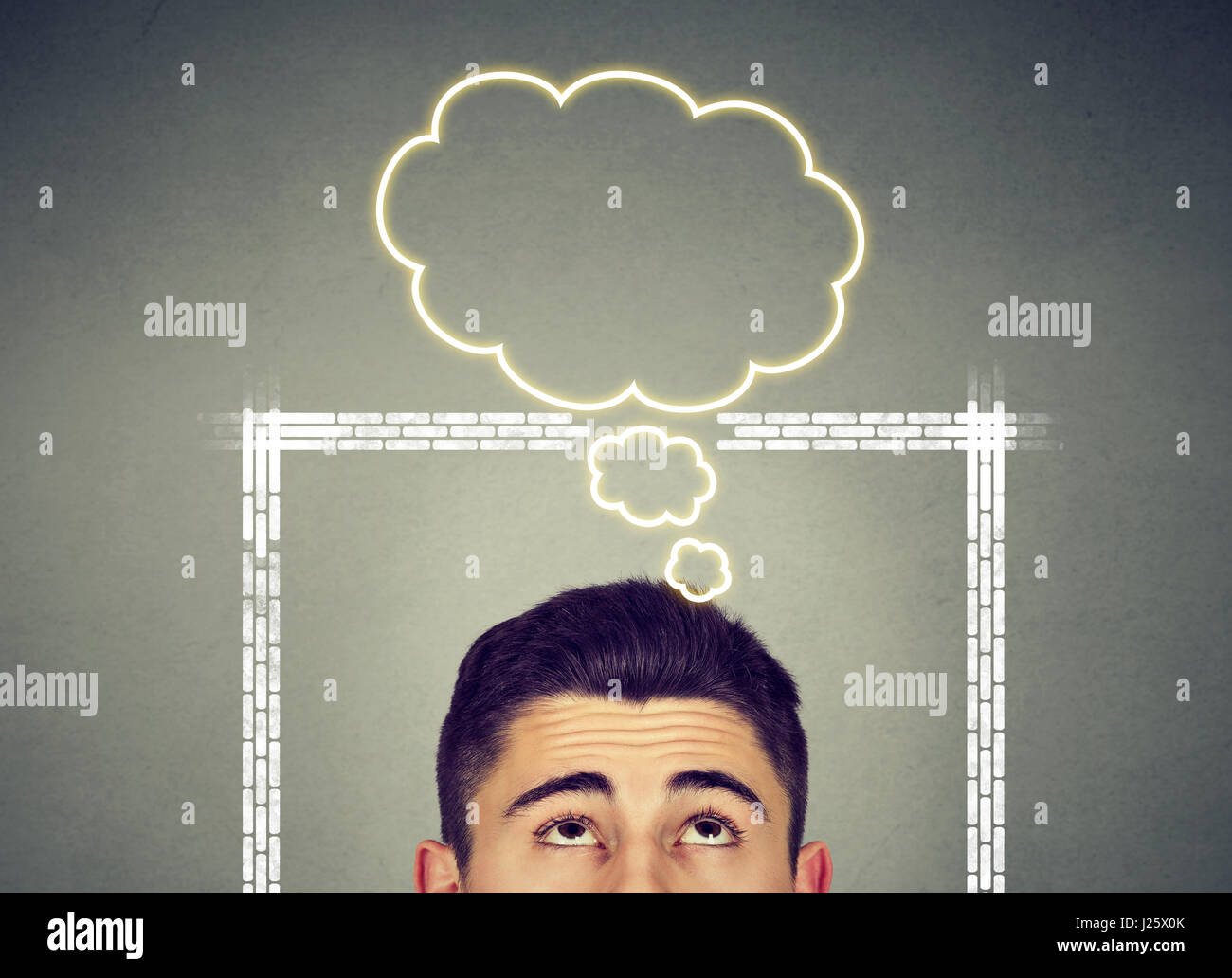 Man thinking outside the box with thought bubble above head isolated on blackboard gray background Stock Photo