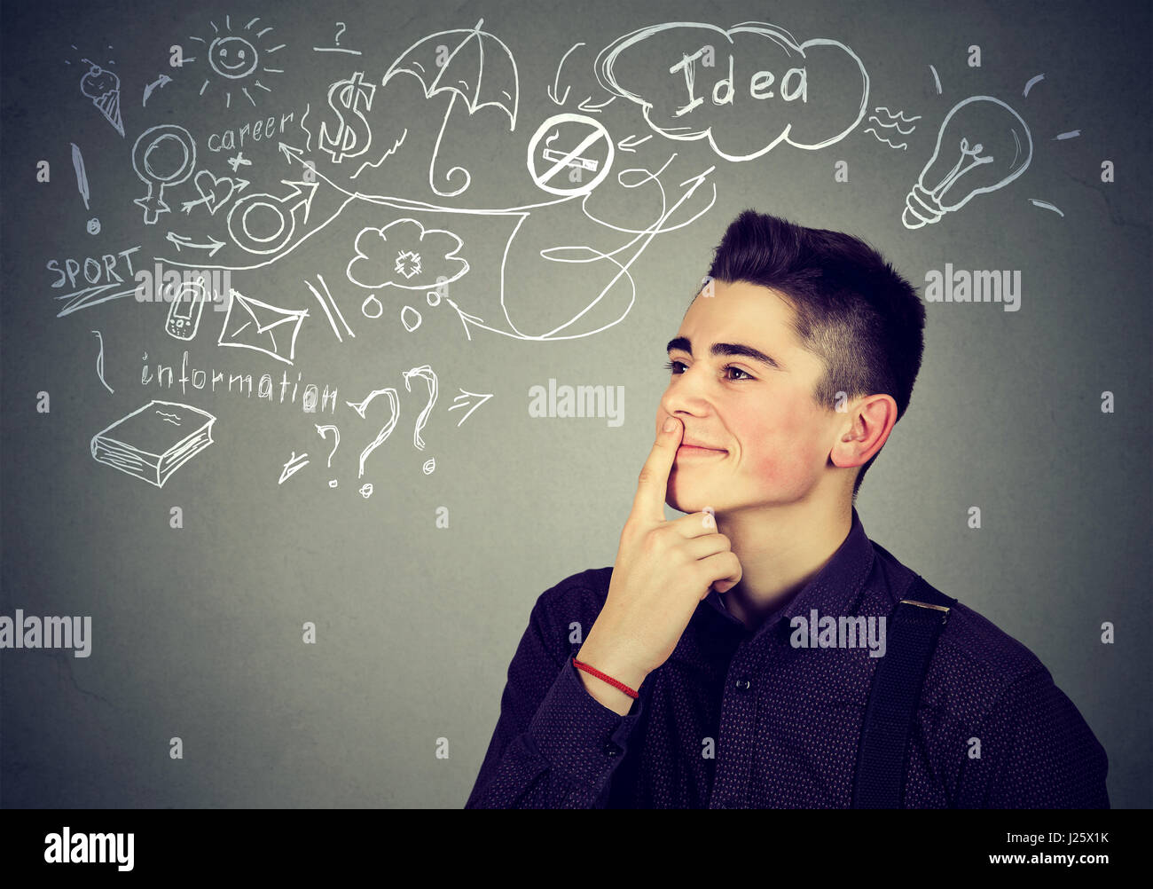 Portrait happy young man thinking dreaming has many ideas looking up isolated gray wall background. Positive human face expression emotion feeling lif Stock Photo