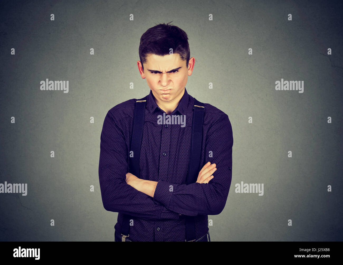 Angry grumpy man looking very displeased isolated on gray wall background. Negative human emotions facial expression Stock Photo