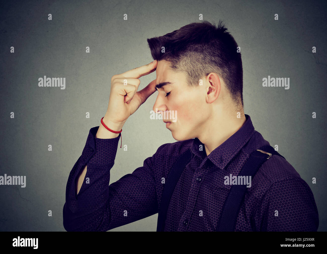 Profile view of sad young man looking down Stock Photo - Alamy