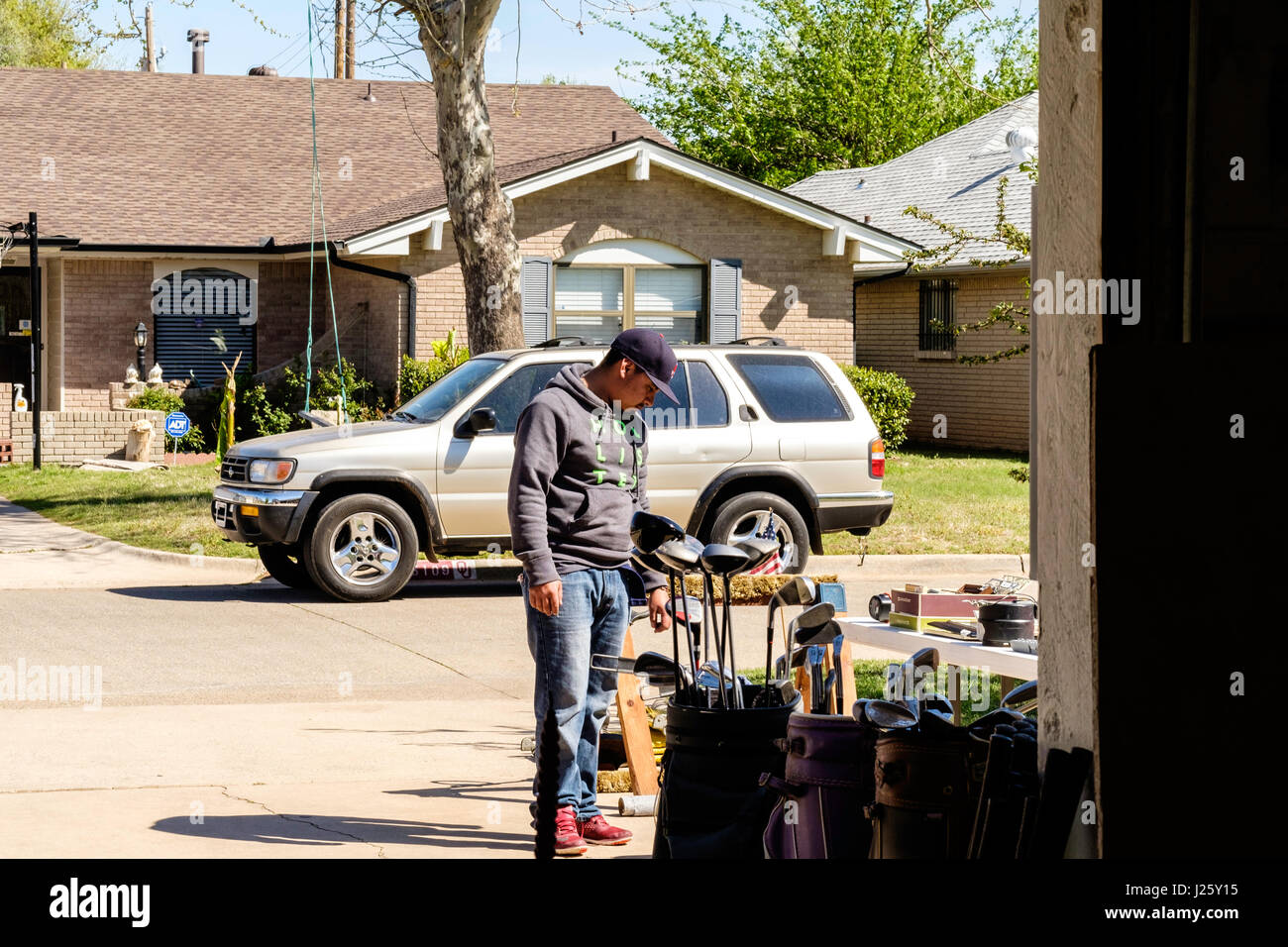 A Hispanic man browses at a garage sale or rummage sale in Oklahoma City, Oklahoma, USA. Stock Photo