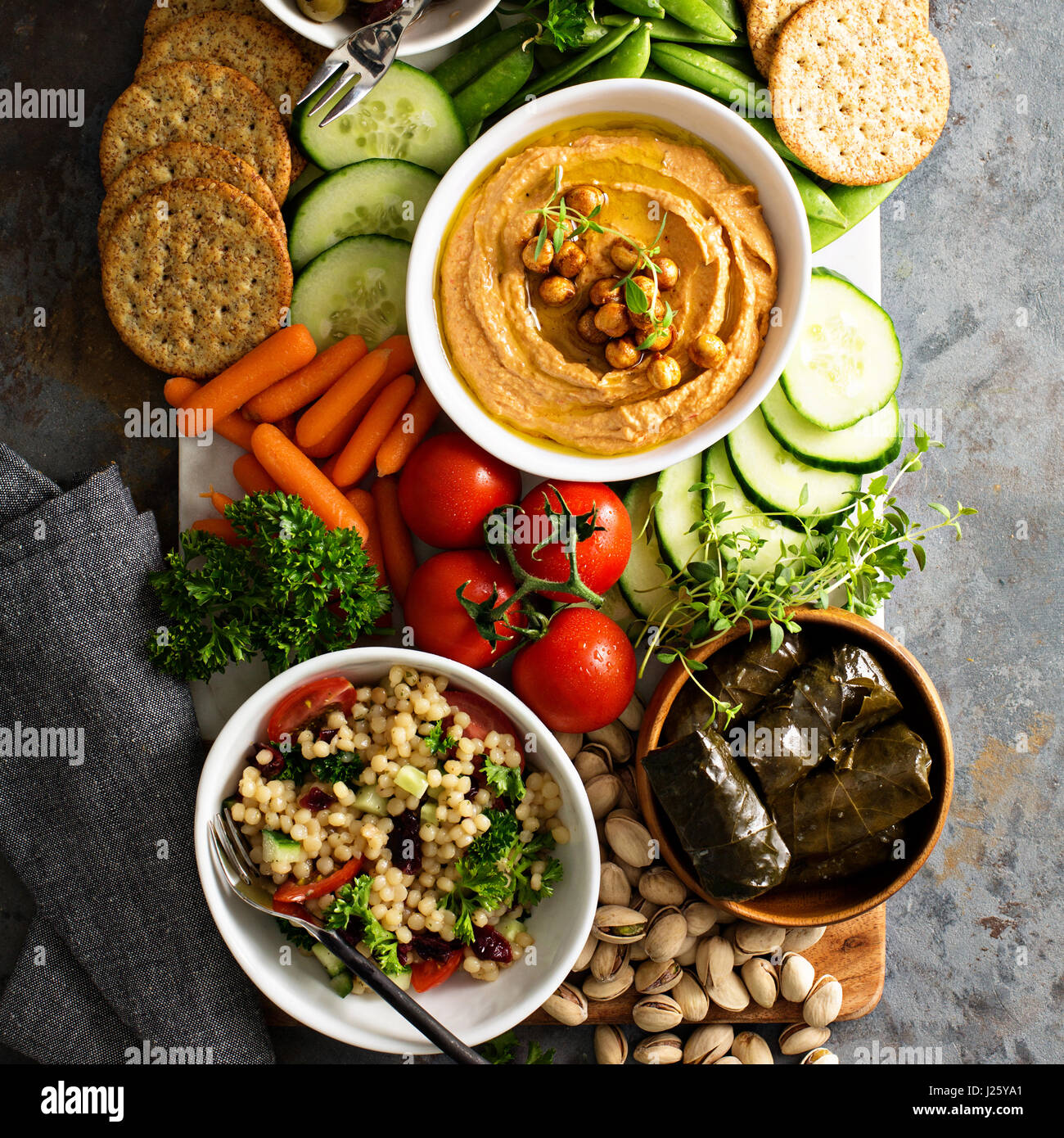 Hummus and fresh vegetables snack platter with grain salad and crackers