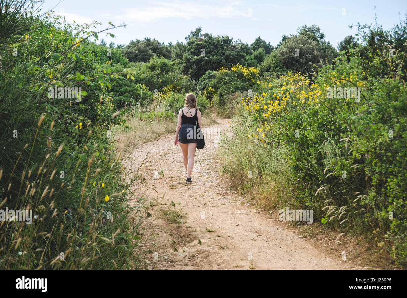 Young Woman Walking Along Path in Field, Kamenjak National Park, Premantura, Croatia Stock Photo