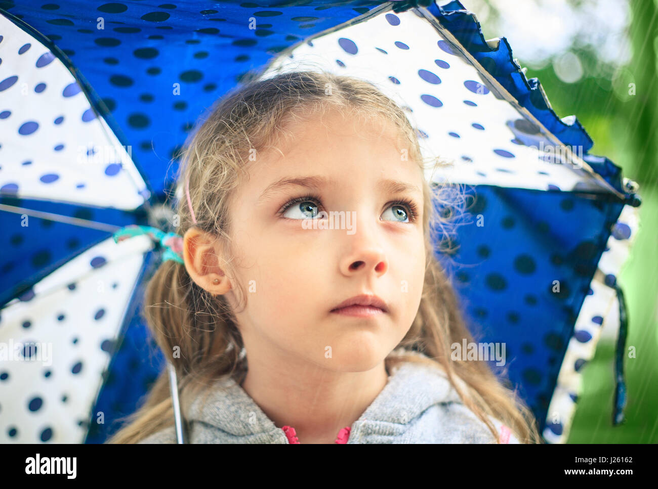 Portrait Of A Cute Sad Girl With An Umbrella In The Rain