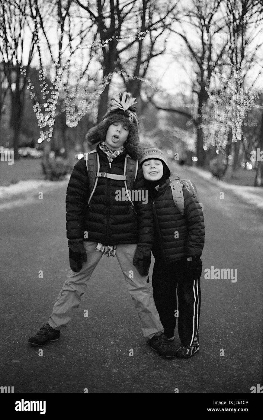Portrait of Two Boys Standing in Middle of Street with Playful  Expressions in Winter Stock Photo