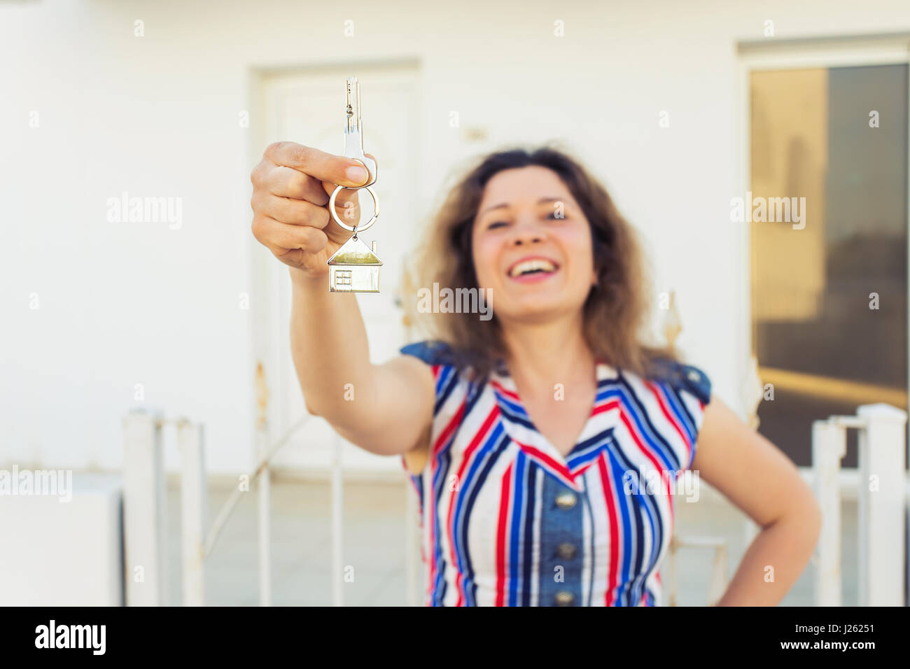 Happy young woman In Front of New Home with New House Keys close up ...