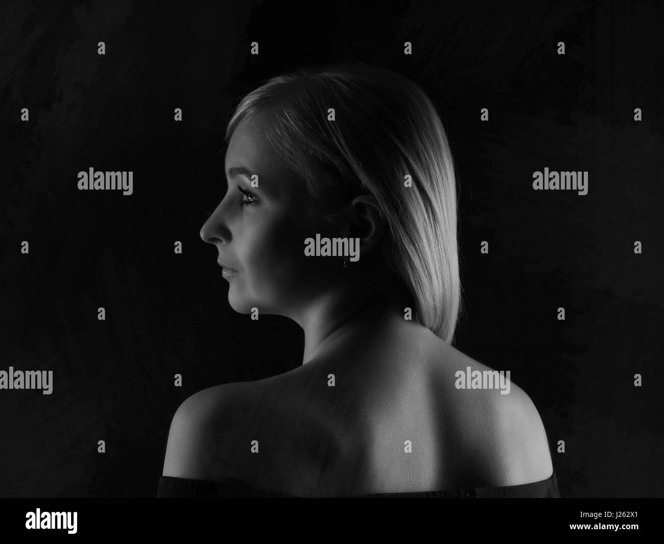 Beautiful girl in a black dress on a gray background Stock Photo - Alamy