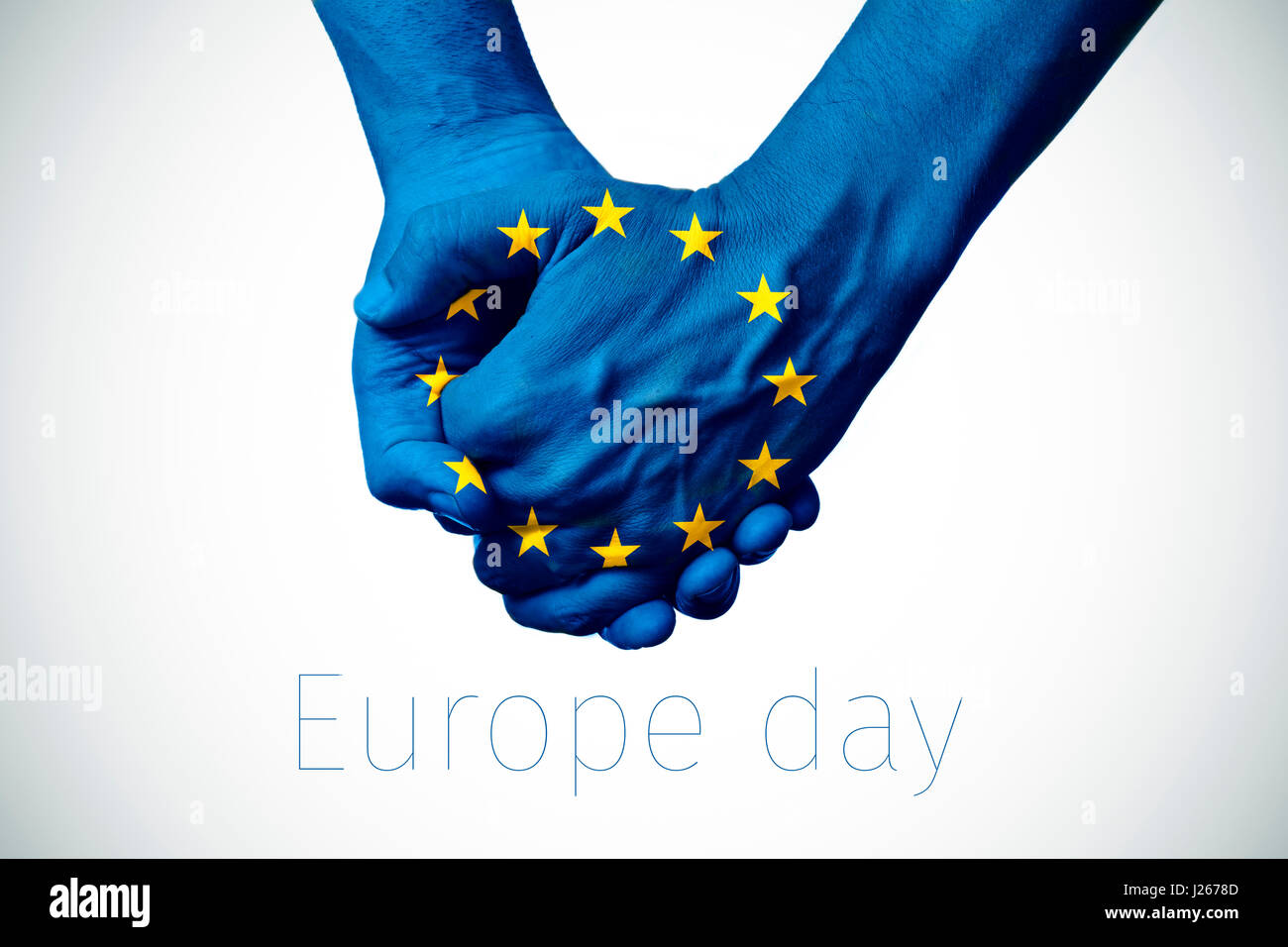 two persons holding hands patterned with the flag of the european community and the text europe day on an off-white background, with a slight vignette Stock Photo