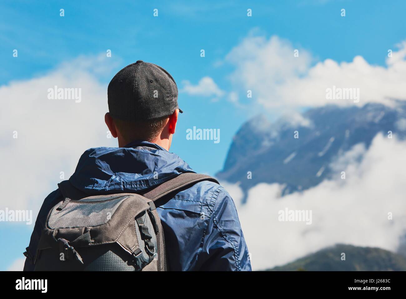 Man with backpack in mountains. Young traveler climbing to Mount 