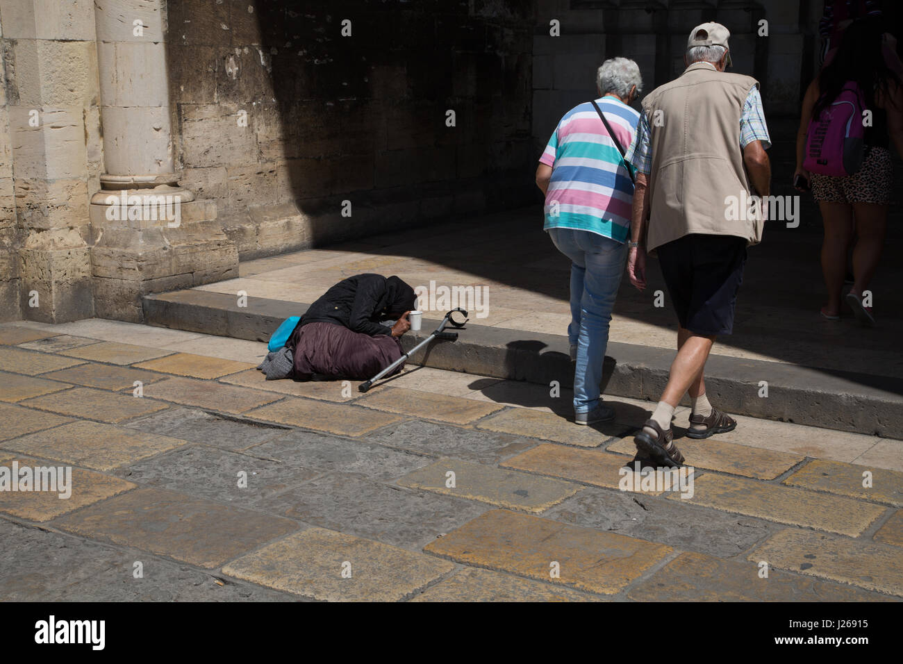 Homeless person on steps of church in Lisbon, Portugal. Stock Photo