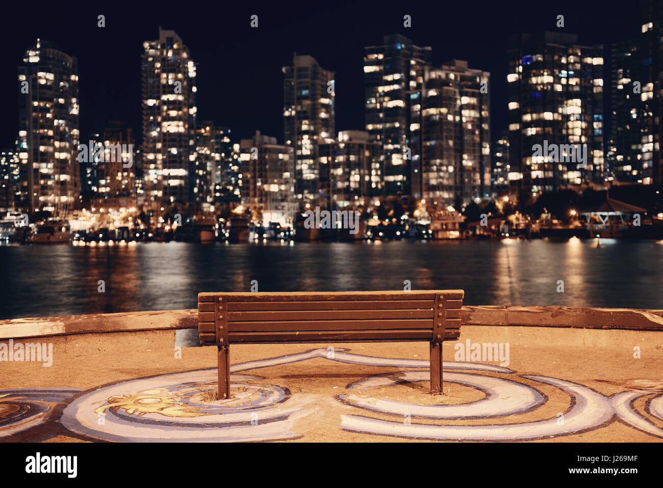 Vancouver city night with bench at waterfront with buildings. Stock Photo