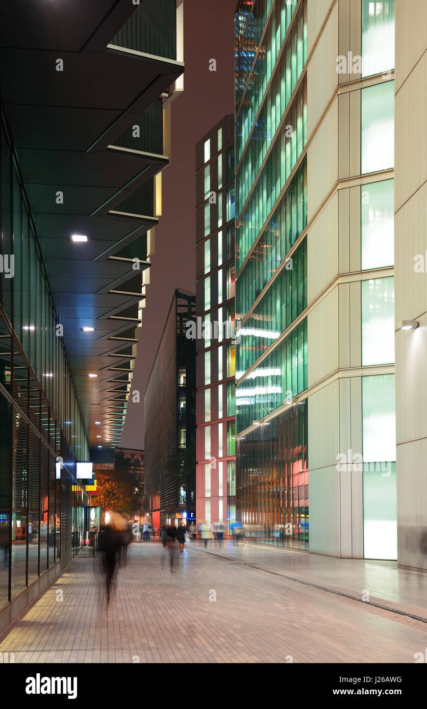 London street view at night with office buildings and pedestrian. Stock Photo