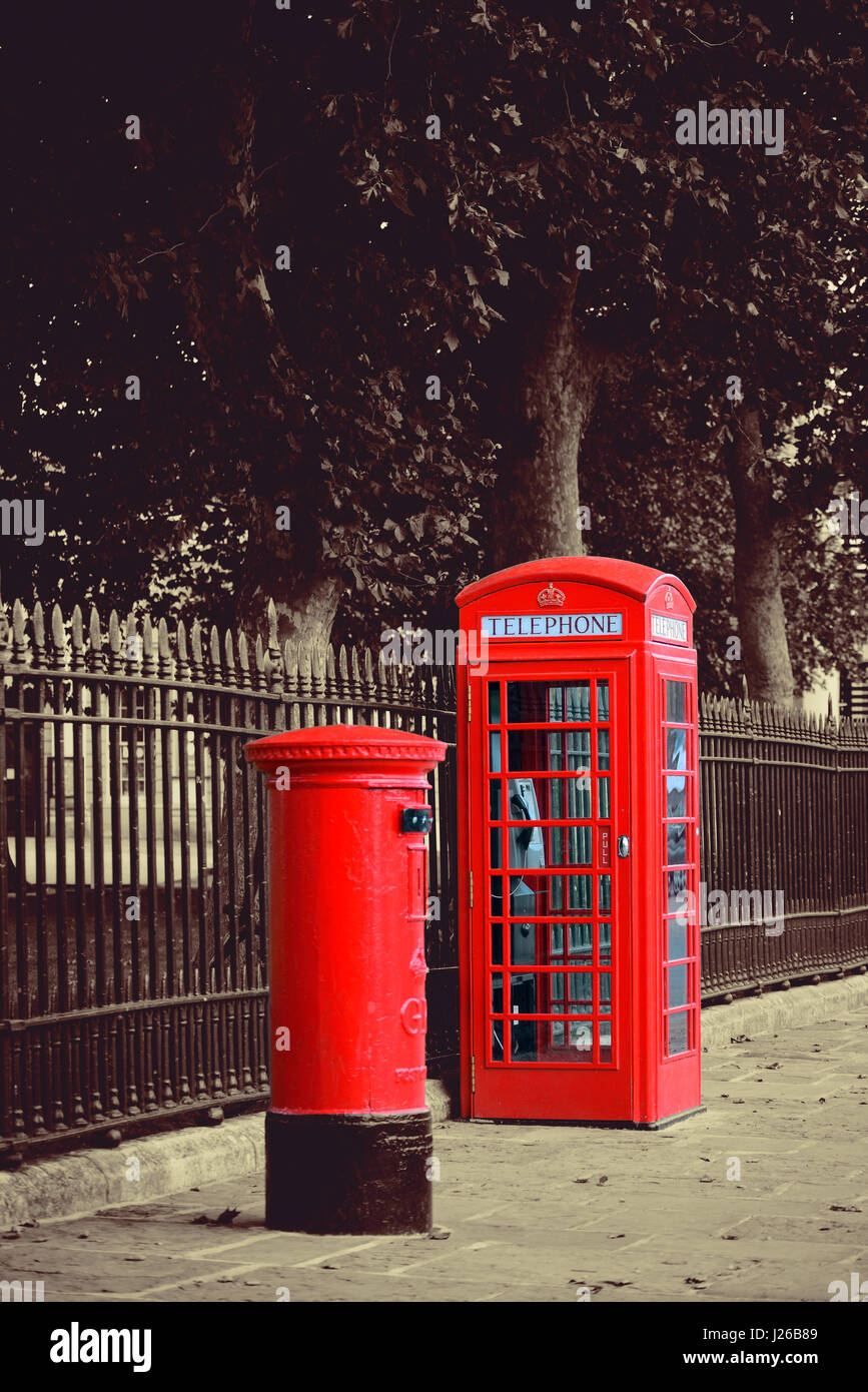 Red telephone and post box in street with historical architecture in London. Stock Photo
