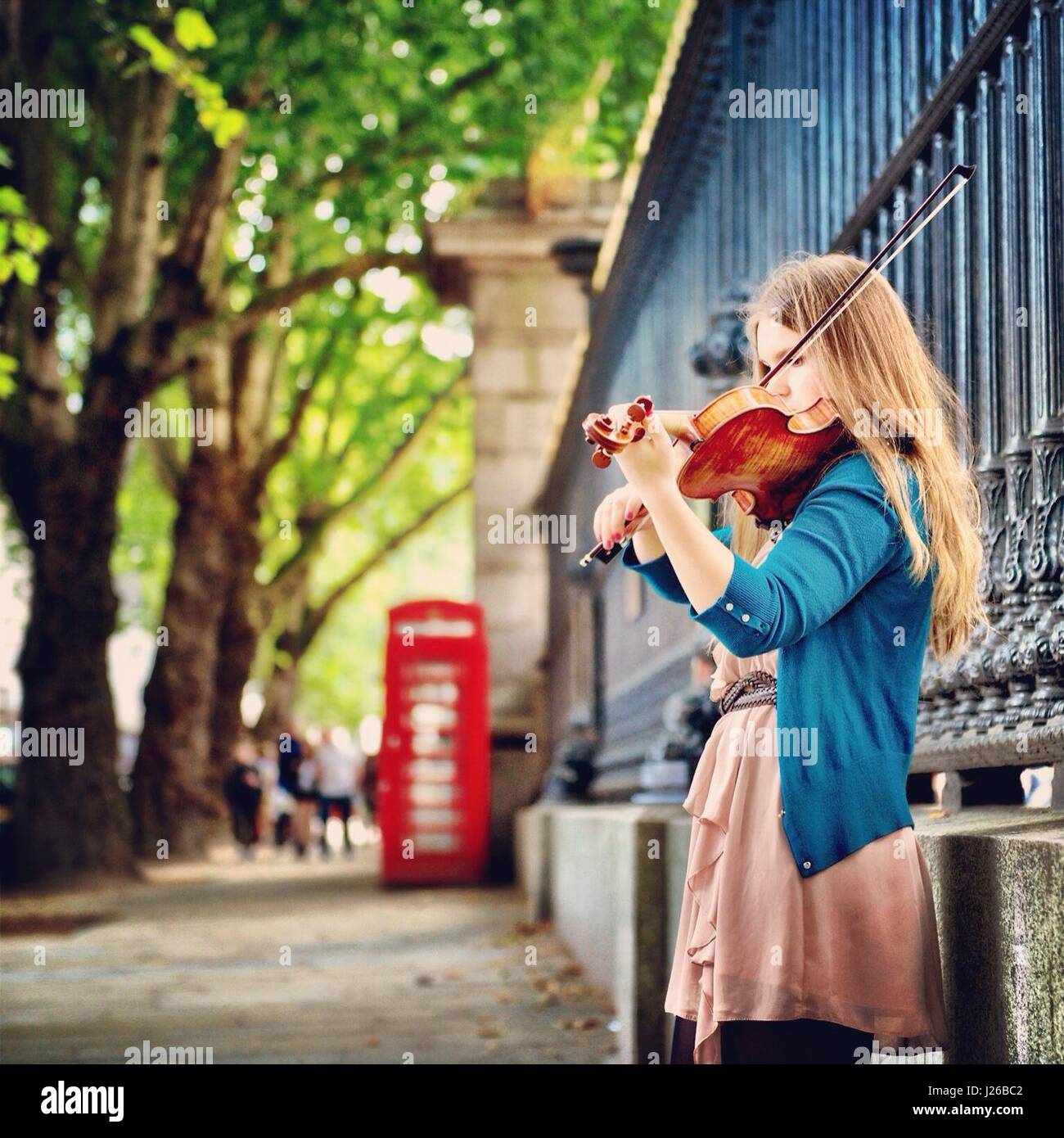 Woman playing the violin in the street, London, England, UK Stock Photo