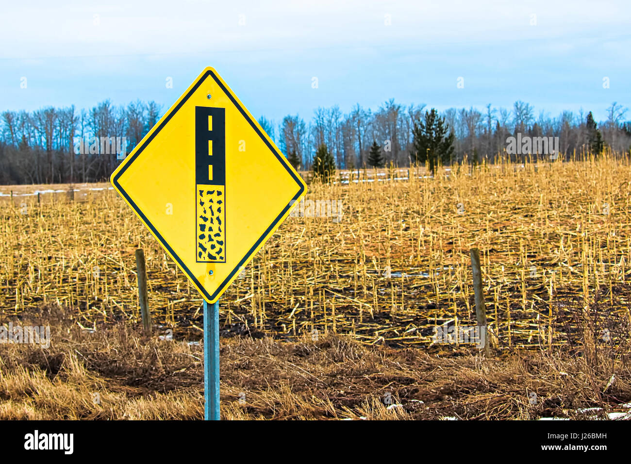 End of gravel road ahead warning sign. Stock Photo