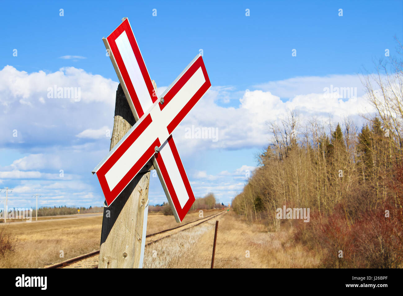 Railroad crossing sign along gravel road. Stock Photo