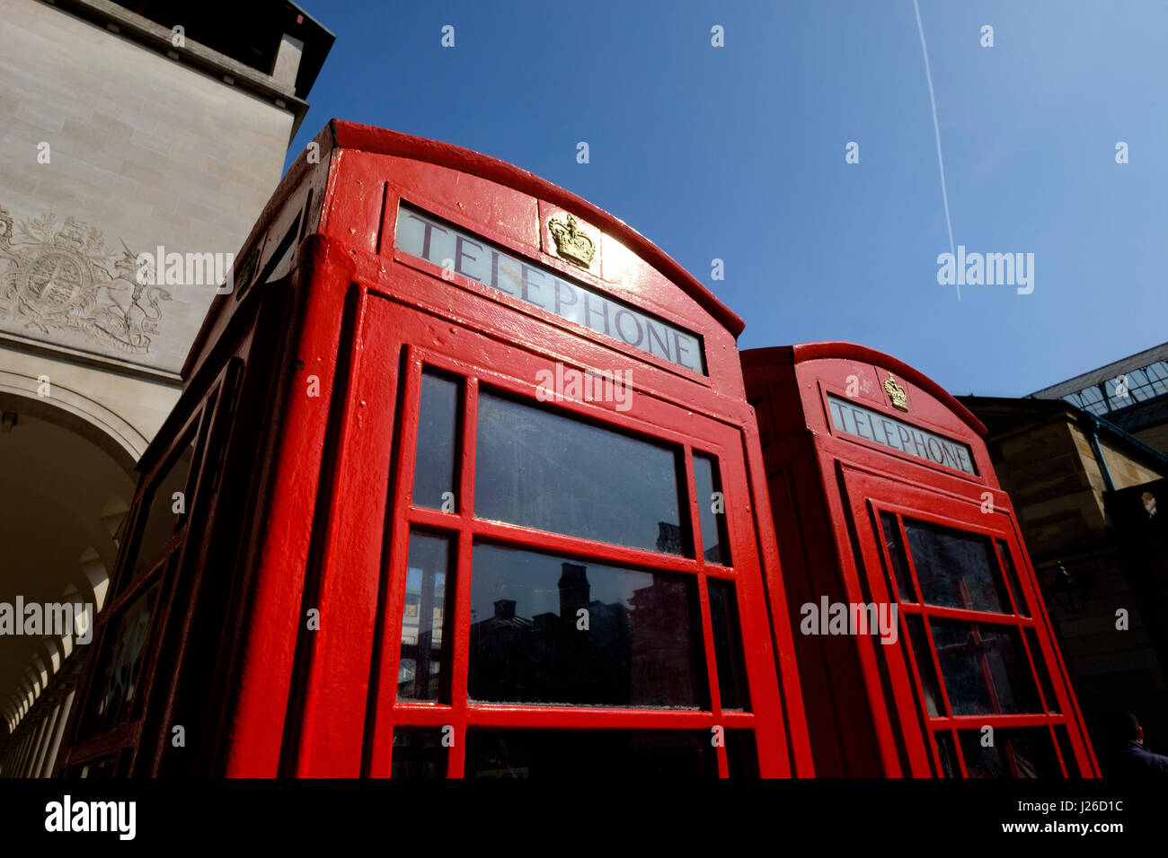 Low angle shot of two red telephone boxes against the blue sky in London, England, UK Stock Photo