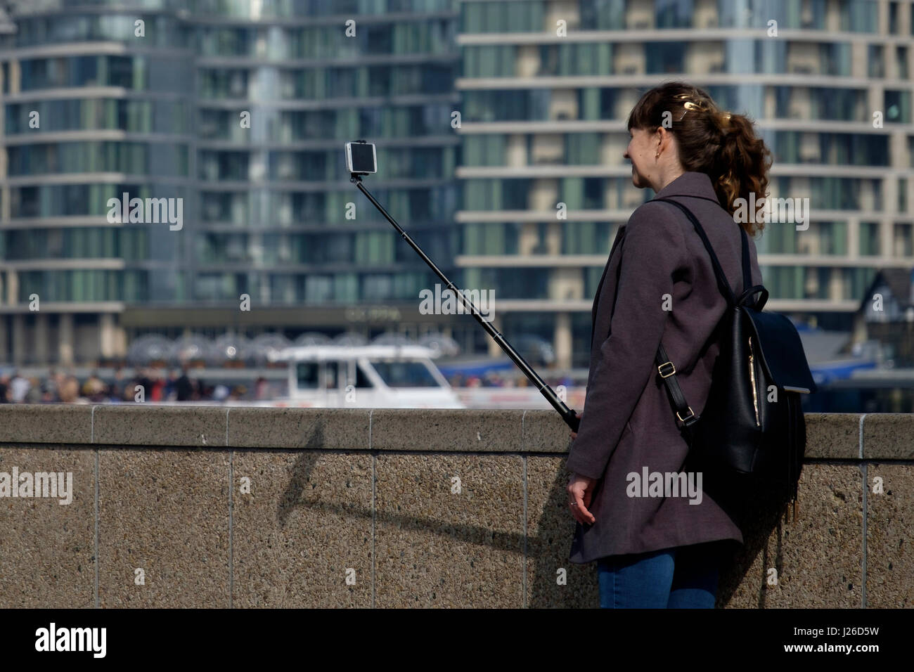 Young woman taking a selfie photo using a selfie stick Stock Photo