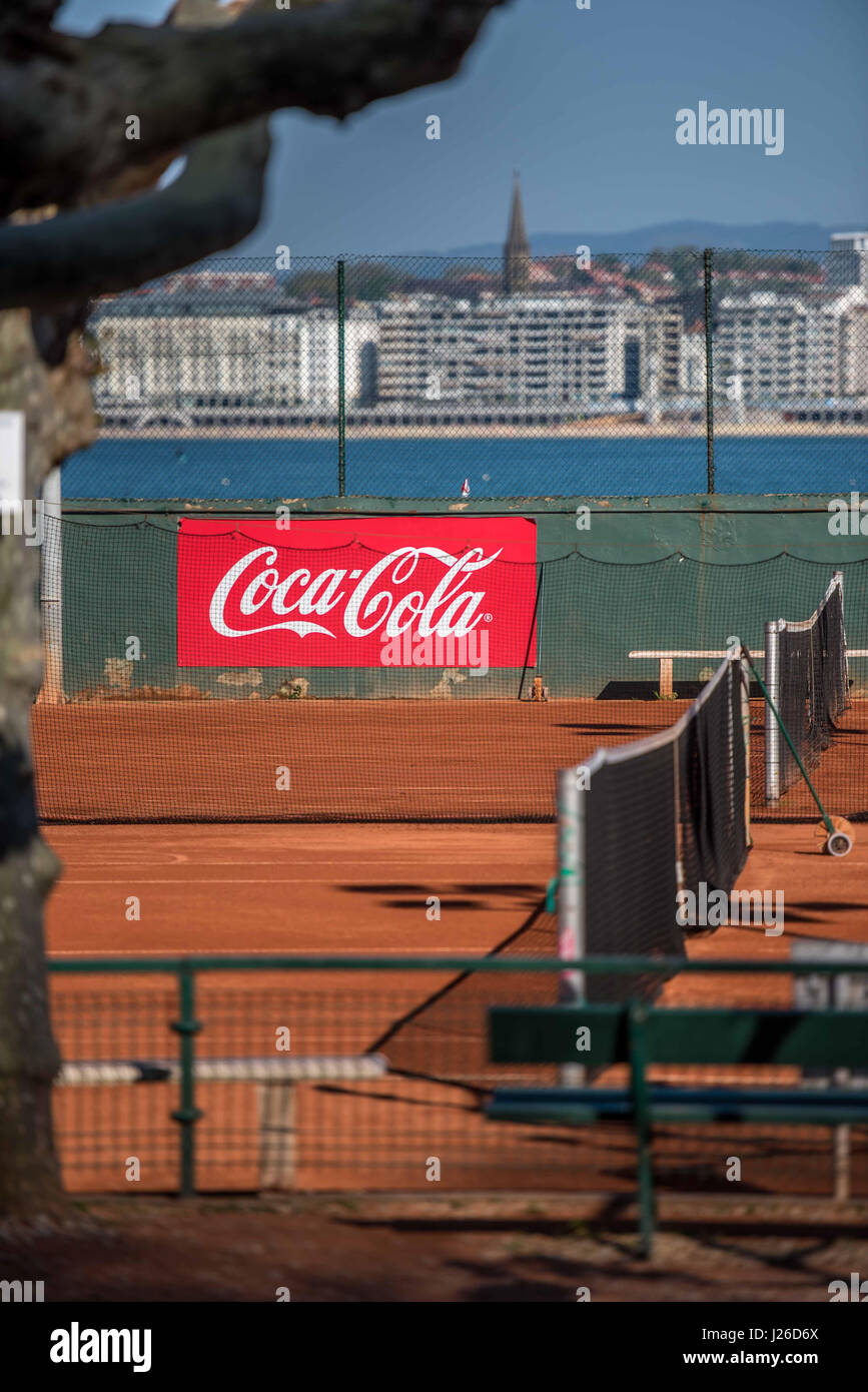 Outdoors tennis court with huge coca cola commercial sign Stock Photo