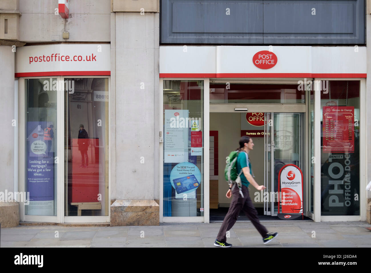 A man with a backpack walks by the post office in London, England, UK