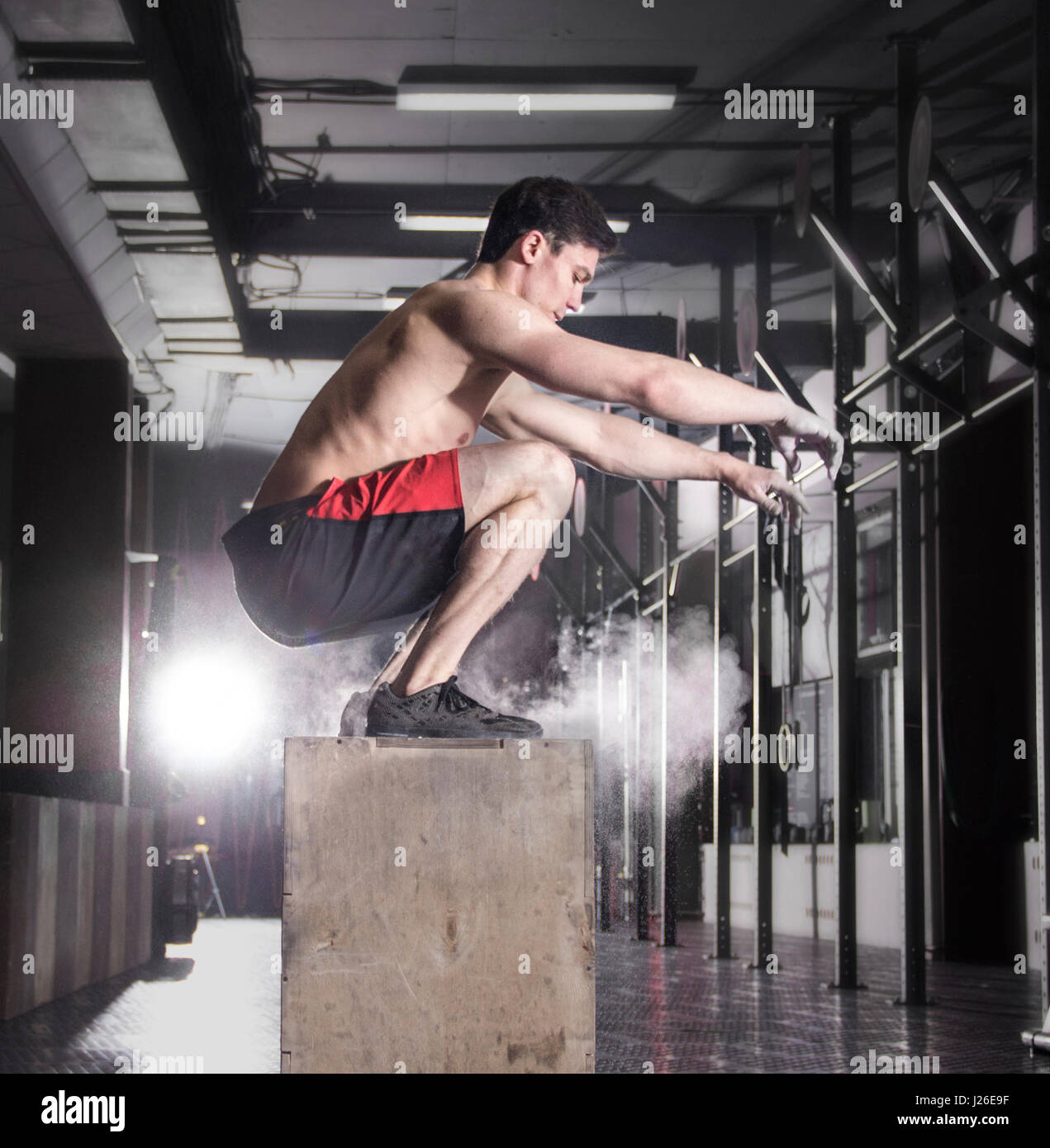 Fit young man box jumping at a crossfit gym.Athlete is performin Stock Photo