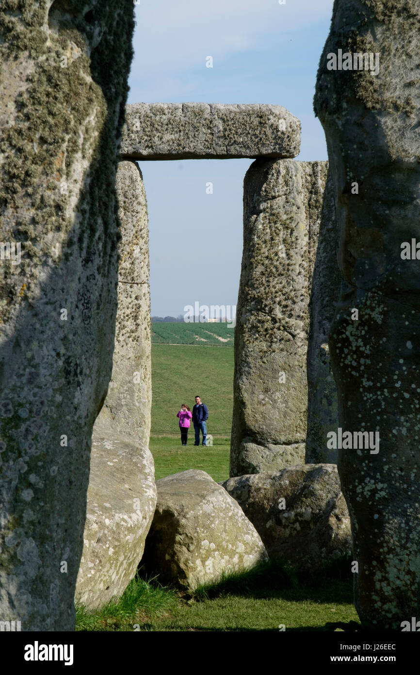Two people visiting the Stonehenge prehistoric monument in Wiltshire, England Stock Photo