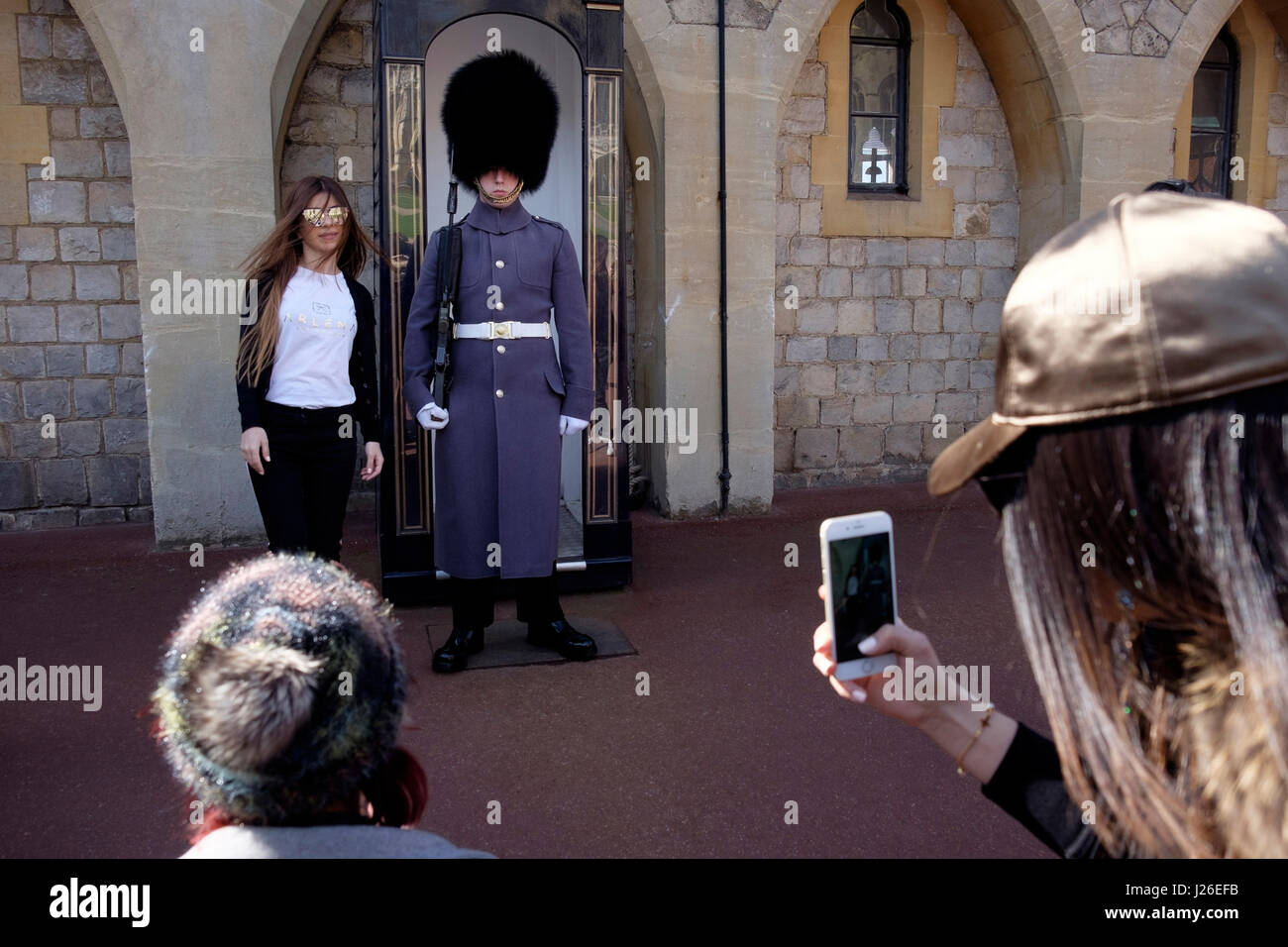 Tourist taking a photo with a Queen's guard in Winter uniform at Windsor Castle, England, UK, Europe Stock Photo