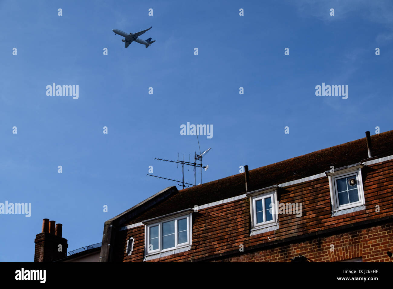 Airplane flying over a house Stock Photo