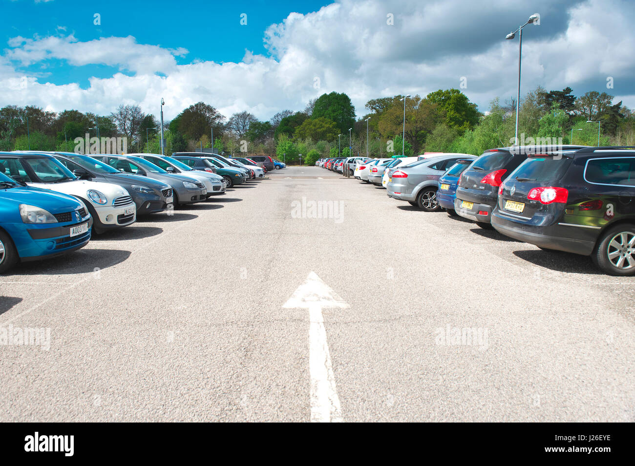 Arrow points straight ahead at an out of town park and ride car park, which is full Stock Photo