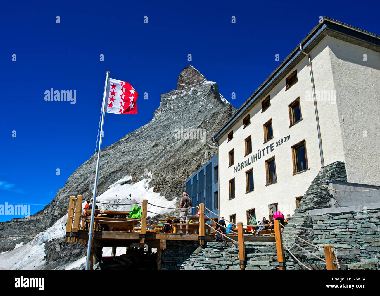 Renovated Hörnlihütte and Valais canton flag at the Matterhorn, Zermatt, Canton of Valais, Switzerland Stock Photo