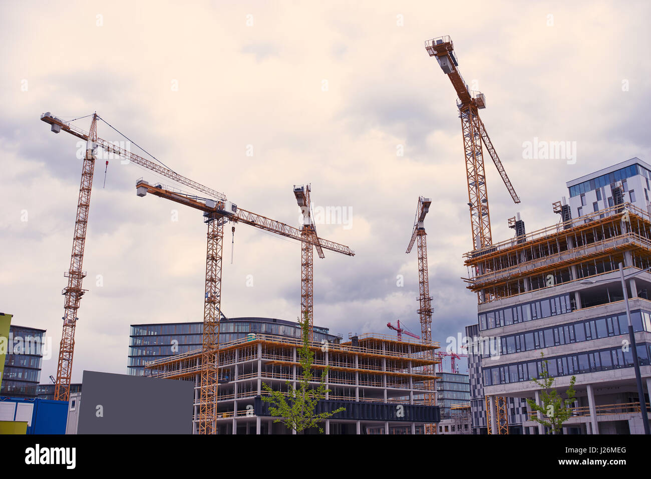 Housing development with cranes and clouds Stock Photo