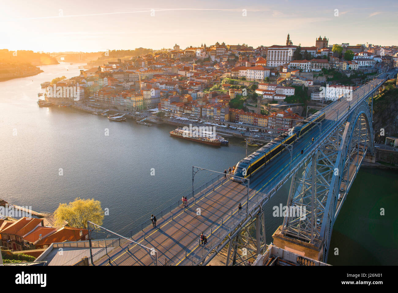 Douro Porto Portugal, view at sunset of a metro train speeding across the upper level of the Ponte Dom Luis I bridge against the Porto skyline . Stock Photo